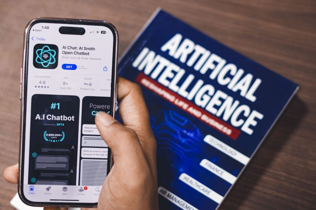 Future of digital marketing concept showing AI chatbot technology on a smartphone beside an artificial intelligence book, representing AI in digital marketing and online marketing innovation